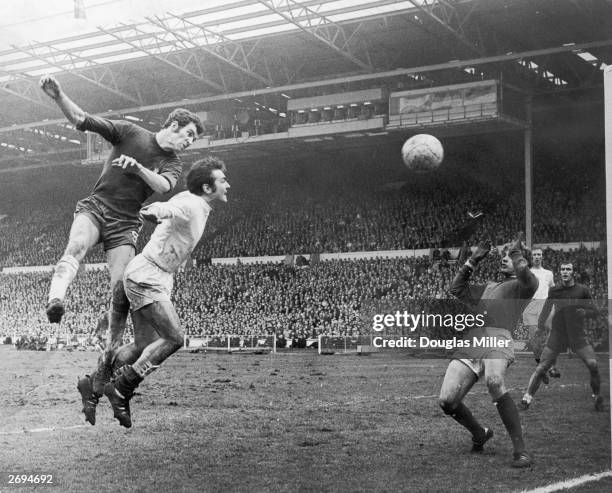 Peter Osgood of Chelsea beats the Leeds United footballer Terry Cooper to the ball during the FA Cup final, while Leeds defender Jack Charlton looks...