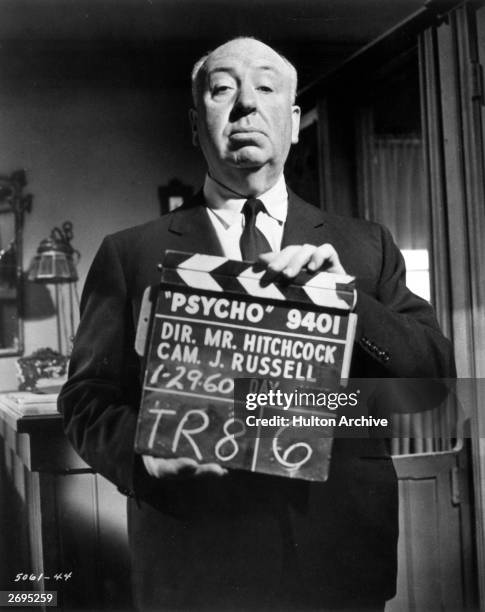 British film director Alfred Hitchcock holding up a clapperboard on the set of his film, 'Psycho', USA, 29th January 1960.