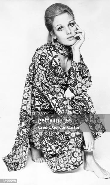 Fashion model wearing a psychedelic patterned button-through shirt-dress and matching scarf from the 'Twiggy' label range.