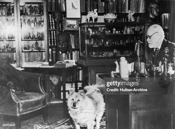 Austrian author and founder of psychoanalysis Sigmund Freud with his chow, Jofi, in his study at Berggasse 19, Vienna, Austria, circa 1937. The photo...