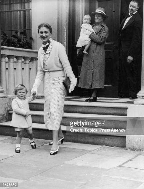 Princess Marina, Duchess of Kent holds the hand of her son Prince Edward as they leave her house in Belgrave Square, London. A nanny carries Princess...