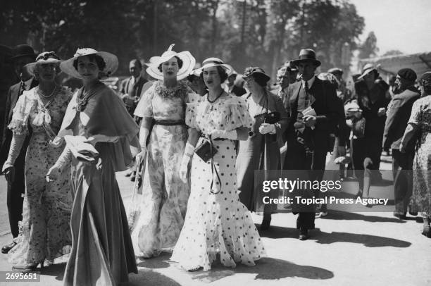 Fashion on the second day at Ascot. Long dresses in various lightweight materials including spotted all worn with gloves and large-brimmed hats.