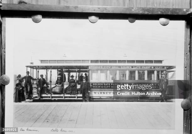 Side view of a cable car with passengers and a conductor, San Francisco, California. The car bears the name of the Market St. Cable Railway Co. And...