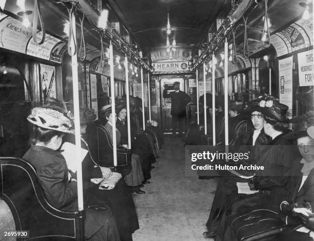 Interior of a subway car with female passengers and a uniformed male conductor.