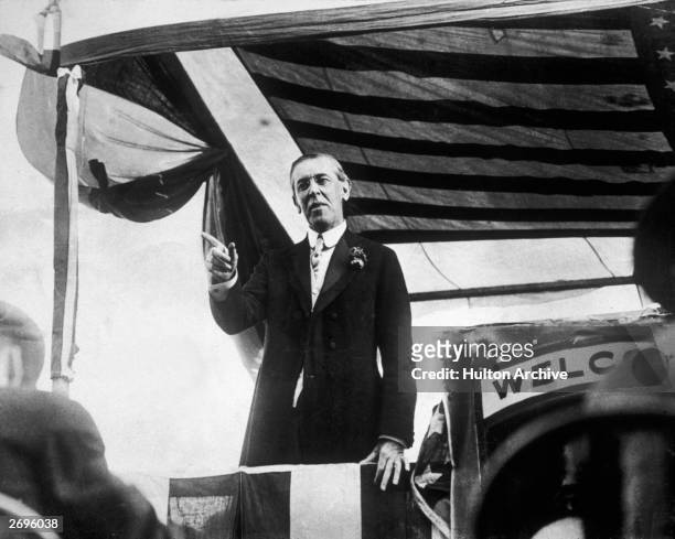 Woodrow Wilson , the 28th president of the United States , points with his finger while making a speech from a platform on his campaign trail,...