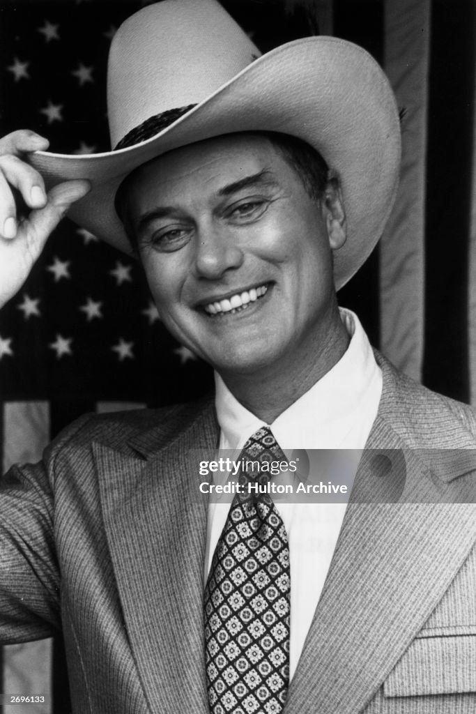 American Actor Larry Hagman As J R Ewing Tips His Cowboy Hat In american-actor-larry-hagman-as-j-r-ewing-tips-his-cowboy-hat-in