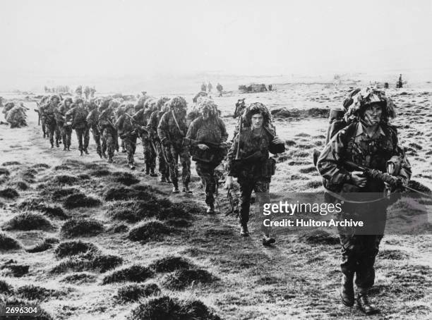 Line of British soldiers in camouflage advancing across East Falkland island for the final attack on Port Stanley during the Falklands War, June 1982.