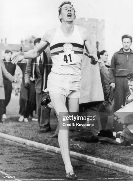 Roger Bannister crossing the tape at the end of his record breaking mile run at Iffley Road, Oxford. He was the first person to run the mile in under...