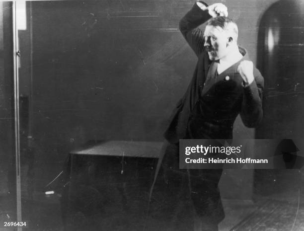 Hitler posing to a recording of one of his speeches after his release from Landsberg Prison.