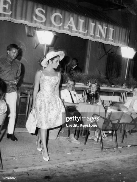 Film star Elizabeth Taylor with co-star Richard Burton leaving 'Tre Scalini', a restaurant in the Piazza Navona, Rome wearing a short dress with...