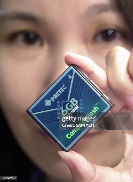 Woman displays a world latest compactflash card during Computex Online Show in Taipei, 04 Novenber 2003. The card works with very low power...
