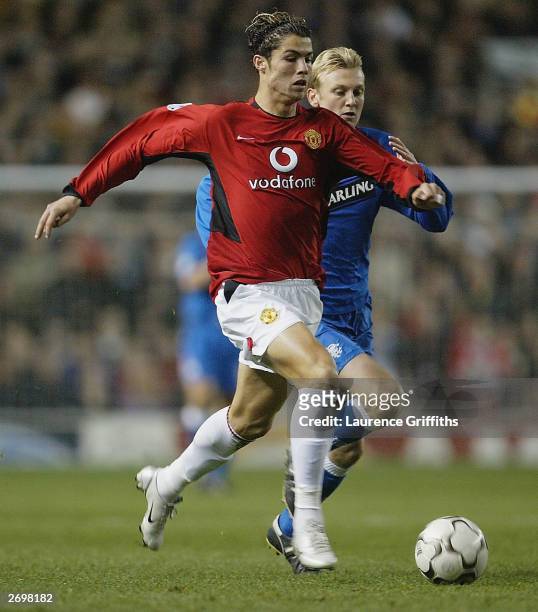 Cristiano Ronaldo of Manchester United is chased by Stephen Hughes of Rangers during the UEFA Champions League match between Manchester United and...