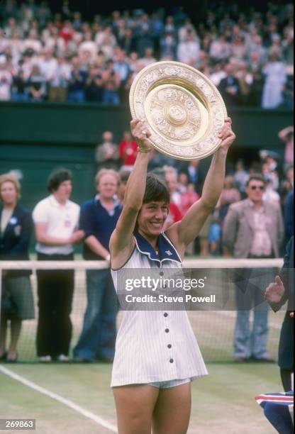 Martina Navratilova holds a trophy after winning at Wimbledon in England.