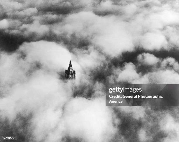 The top of the Woolworth Building in New York above the clouds. It was designed by Cass Gilbert and was the second tallest building in the world at...