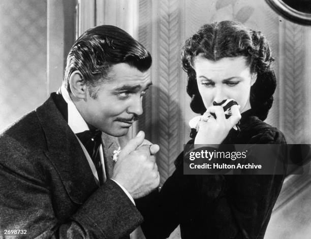 American actor Clark Gable in his role as Rhett Butler kissing the hand of a tearful Scarlett O'Hara, played by Vivien Leigh in 'Gone With The Wind'.