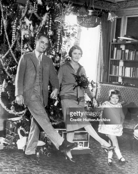 American author F Scott Fitzgerald dances with his wife Zelda Fitzgerald and daughter Frances in front of the Christmas tree in Paris.