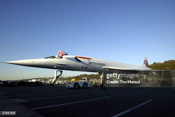 British Airways Concorde passenger jet is towed on the rampway, while pilot Cpt. Mike Bannister waves a British flag November 5, 2003 at Boeing Field...
