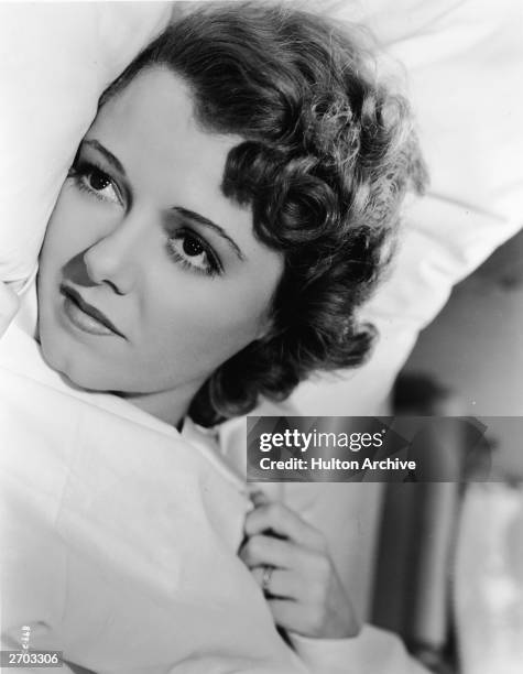 Headshot portrait of American actor Janet Gaynor lying in bed in an unidentified film still, circa 1930.