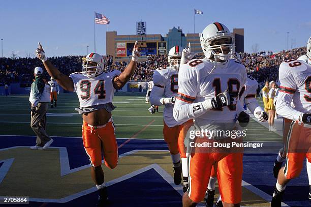 Defensive end Dwayne Johnson of the University of Miami Hurricanes raises his arms as he and his teammates leave the field during the NCAA game...