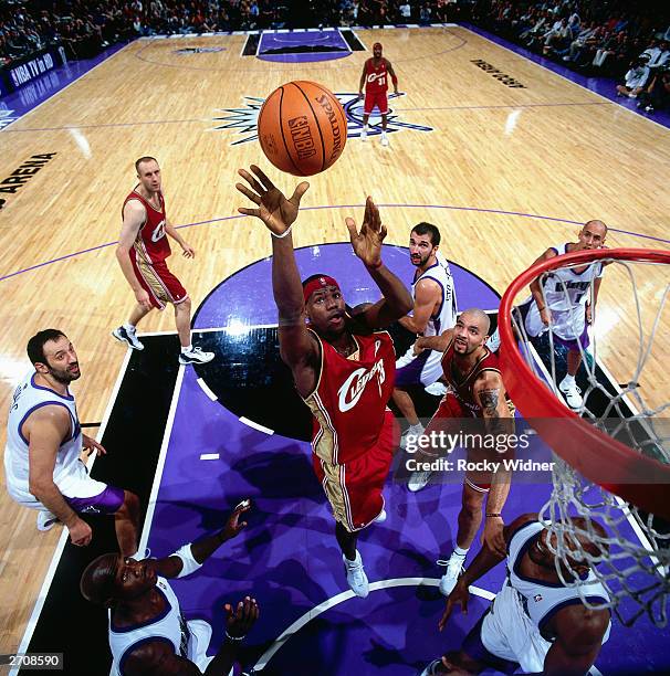 LeBron James of the Cleveland Cavaliers goes for a rebound against the Sacramento Kings during the NBA game at the Arco Arena on October 29, 2003 in...