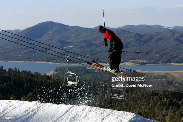 Skier jumps on an especially early opening day for the ski season at Big Bear Mountain with man-made snow as residents return from evacuation due to...
