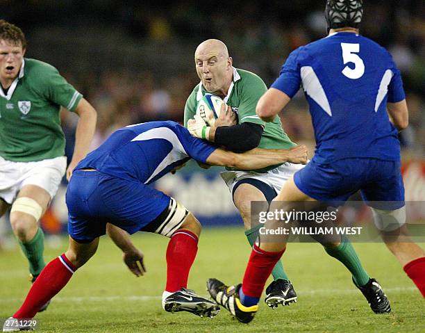 Irish hooker and captain Keith Wood is tackled by French lock Jerome Thion and French lock Fabien Pelous during Rugby World Cup quarter-final match...