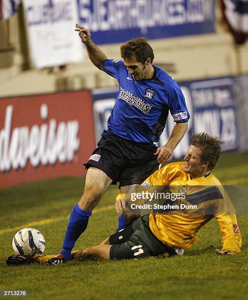 Sasha Victorine of the Los Angeles Galaxy tackles the ball away from Brian Mullan of the San Jose Earthquakes in their Major League Soccer Western...