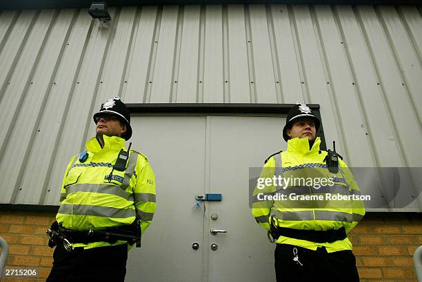 Police stand next to the door of the shelter where the cloths of the two girls were found in a bin , November 10, 2003 in Soham, England....