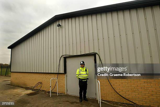 Policeman stands in front of the door of the shelter where the cloths of the two girls were found in a bin November 10, 2003 Soham, England....