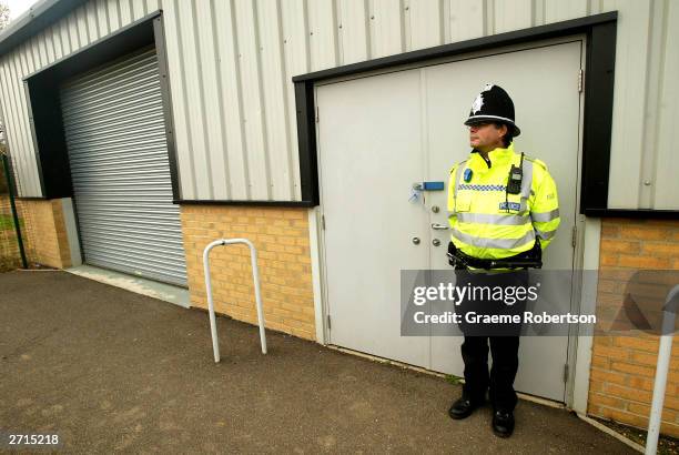 Policeman stands in front of the door of the shelter where the cloths of the two girls were found in a bin November 10, 2003 in Soham, England....