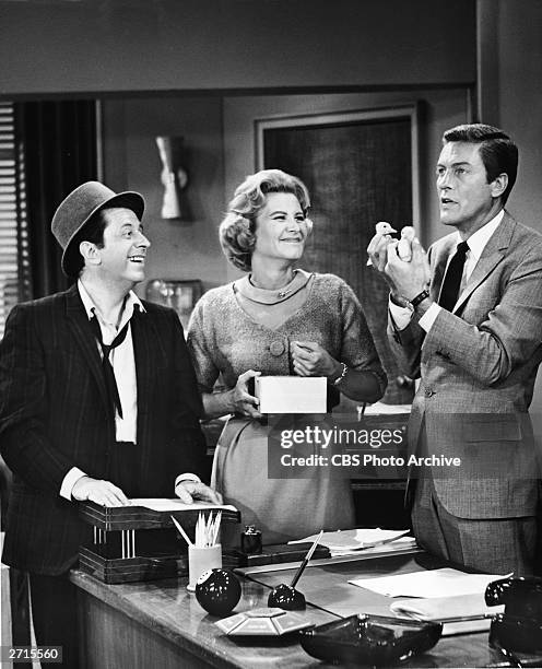 American actors Morey Amsterdam and Rose Marie smile as actor Dick Van Dyke holds up two ducklings in a still from the television series, 'The Dick...