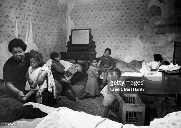 Large family living in cramped accommodation. Original Publication: Picture Post - 4825 - Is There A British Colour Bar - pub. 1949