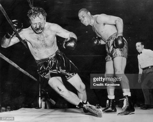 Battered and bloody Lee Savold falls against the ropes following an onslaught from former world heavyweight boxing champion Joe Louis during their...