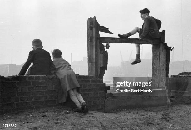 Children look over the shipping in the Pool of London, off Wapping High Street, London. Original Publication: Picture Post - 4931 - The Pool Of...