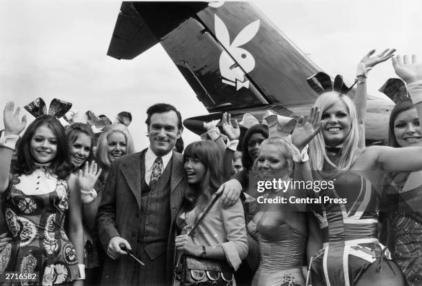 Hugh Hefner, American editor, publisher and founder of Playboy magazine, and his girlfriend Barbi Benton are welcomed by 'Bunny Girls' from the...