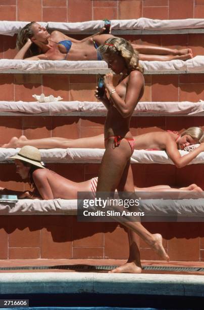 Catherine Wilke joins the topless sunbathers at the Hotel Punta Tragara on the island of Capri, Italy, 1980.
