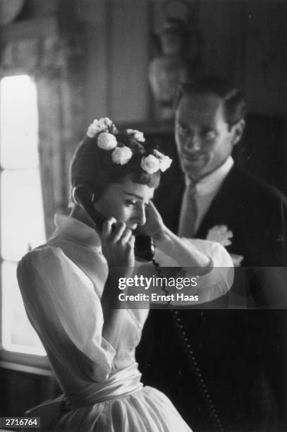 Premium Rates Apply. Film star couple Audrey Hepburn and Mel Ferrer on their wedding day. Dress designed by Balmain.