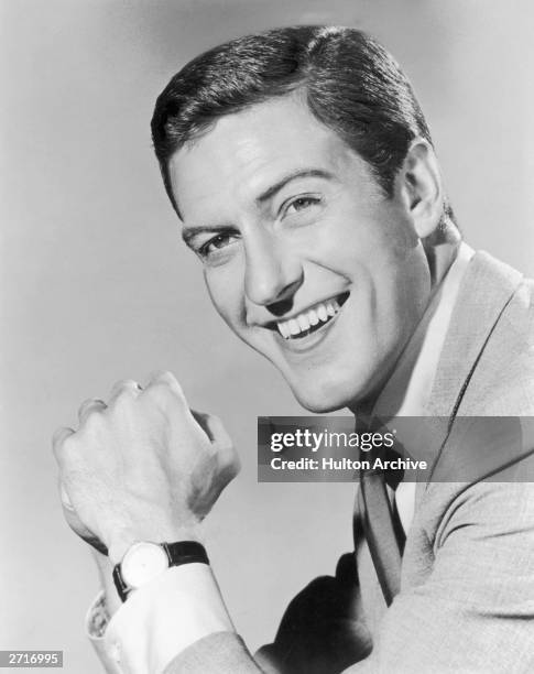 Headshot portrait of American actor and comedian Dick Van Dyke smiling with his hands clasped in front of him.