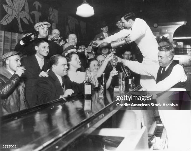 Bartenders at Sloppy Joe's bar pour a round of drinks on the house for a large group of smiling customers as it was announced that the 18th Amendment...
