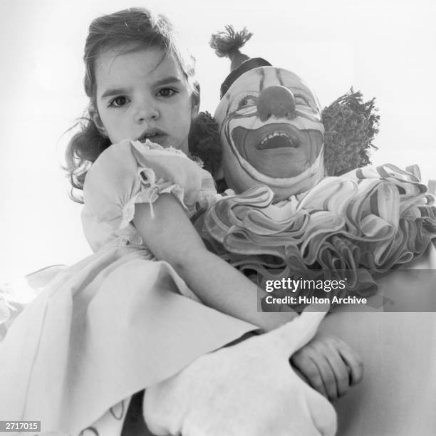 American actress and singer Liza Minnelli as a child in the arms of Bozo the Clown at a children's Easter party in Hollywood.