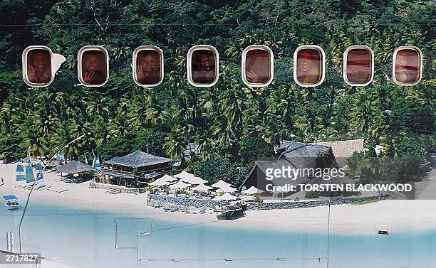 Passengers can be seen through the windows of an Air Pacific Boeing 747-400 series aircraft featuring a mural of idyllic Castaway Island in the...