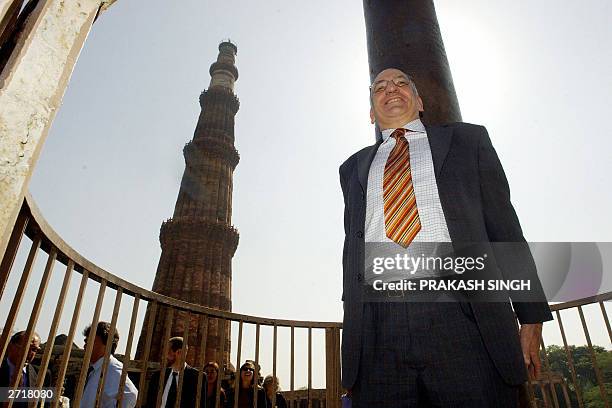 Swiss President Pascal Couchepin attempts to join his hands around an Iron pillar during his visit to the famed Qutab Minar complex in New Delhi, 11...