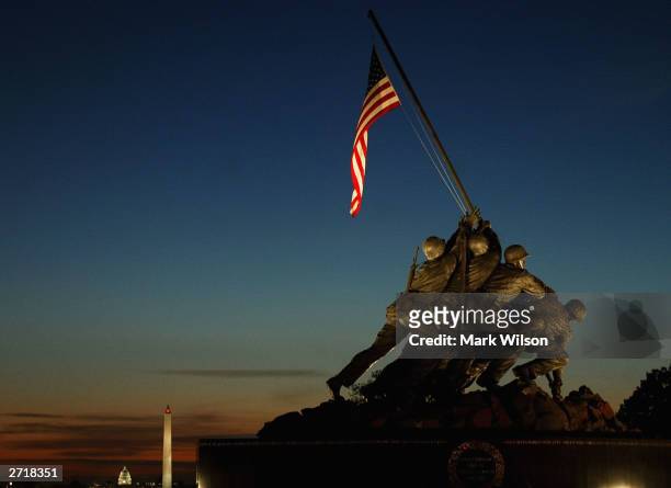 The early morning sun begins to rise behind the Iwo Jima Memorial, November 11, 2003 in Arlington, Virginia. Many Veterans Day events will take place...