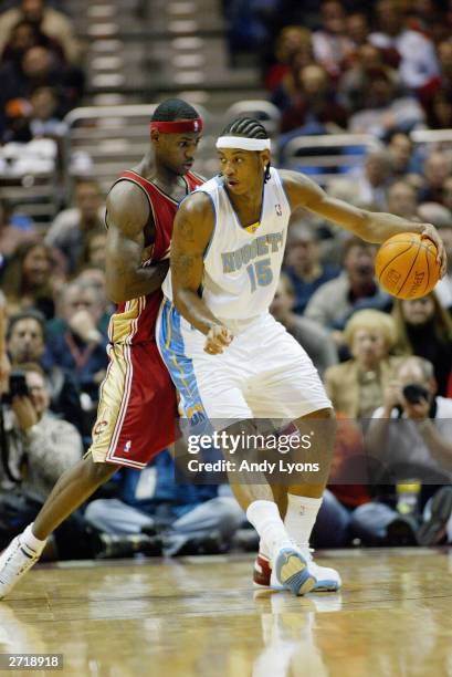 Carmelo Anthony of the Denver Nuggets is defended by LeBron James of the Cleveland Cavaliers during the game on November 5, 2003 at Gund Arena in...