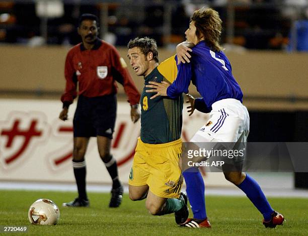 Australian U-20 forward and captain Scott McDonald is tackled by Japanese U-20 defender Mitsauru Nagata to get a penalty kick during the second half...