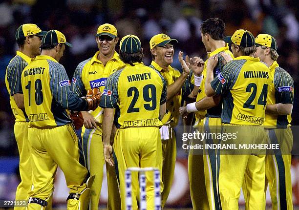 Australian cricketers celebrate during a day-night match of the triangular one-day cricket series against India at the Chinnaswamy Stadium in...