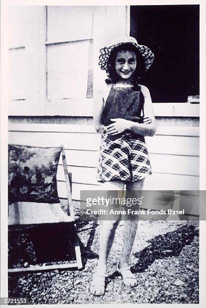 Portrait of German Jewish diarist Anne Frank smiling outside the family home, wearing a straw hat, circa 1940.