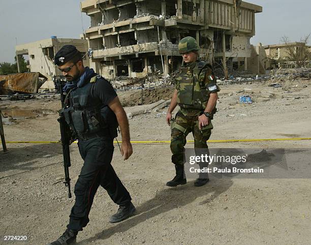 An Italian Carabinieri and military police walk near the destroyed Italian military police headquarters on November 13, 2003 in Nasiriyah, Iraq. A...
