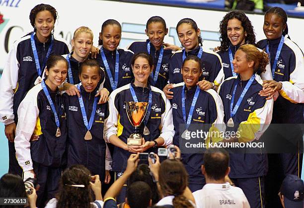 Brazilian volleyball team captain Fernanda Venturini and teammates pose for photographers during the awards ceremony with their trophy and silver...
