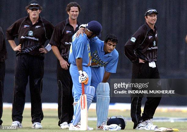 Indian batsman Virender Sehwag supports his captain Sourav Ganguly as New Zealand cricketers Kyle Mills , Chris Cairns and Chris Harris look on...